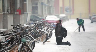 小伙子跪在樓前，一直抬頭看著樓上。 孫立國/攝