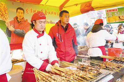 賣羊肉串攤位老板趙山（穿紅衣者）。新京報記者