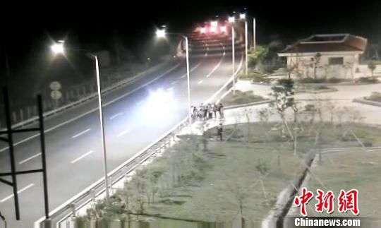看到車輛經(jīng)過，孩子們便急忙跑到一旁的花圃上?！【焦﹫D　攝