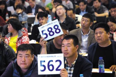昨日，拍賣現(xiàn)場競拍者舉牌競拍。新京報記者