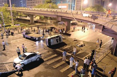路虎沖下國(guó)貿(mào)橋砸中一輛起亞轎車(chē)，橋上厚達(dá)幾十厘米的水泥護(hù)欄被撞斷，碎石四處散落，數(shù)十群眾在現(xiàn)場(chǎng)圍觀。