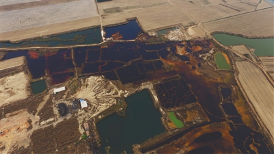 4月19日，廊坊市大城縣南趙扶鎮(zhèn)，津保路以北約八九百米處，一個(gè)巨大的污水坑中，水體呈現(xiàn)紅褐色。 新京報(bào)記者 尹亞飛 攝