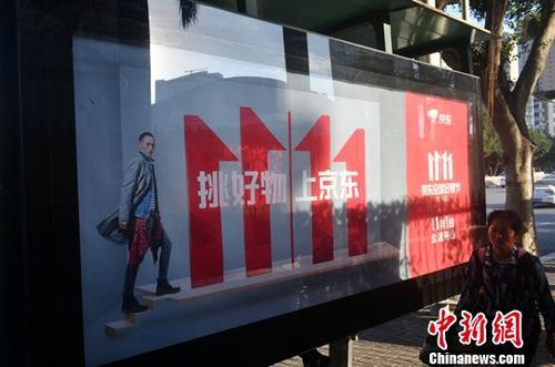 資料圖：11月1日，福州民眾從雙十一廣告牌前經(jīng)過。中新社記者 呂明 攝