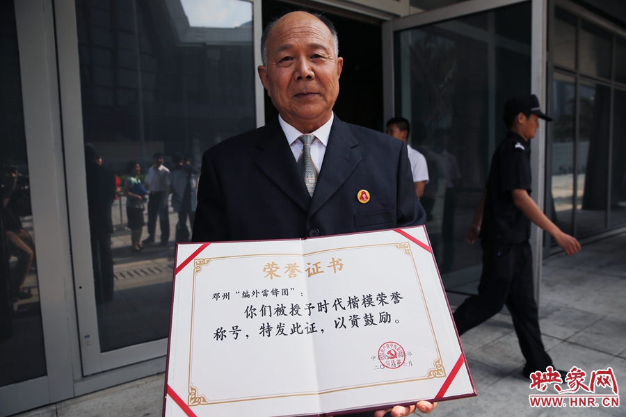 河南鄧州“編外雷鋒團(tuán)”團(tuán)長宋清梅向眾多記者展示中宣部授予的“時(shí)代楷?！睒s譽(yù)證書。