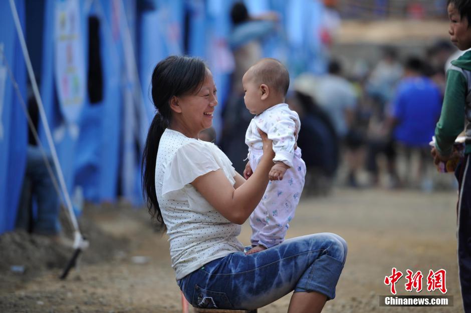 8月6日，一名年輕的母親在和孩子玩樂。