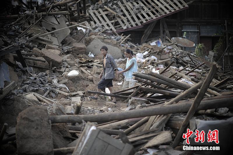 2014年8月5日，云南昭通龍頭山鎮(zhèn)老街，一對夫妻從居住房屋的廢墟中走過。