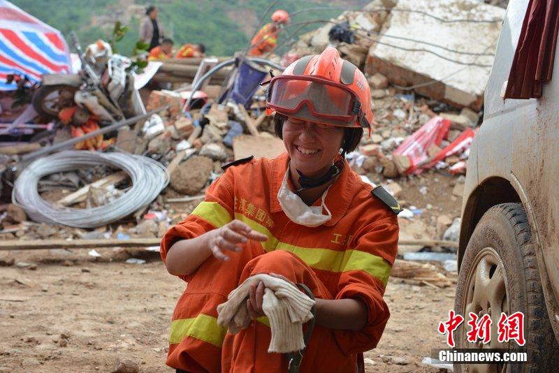2014年8月5日，女兵在云南魯?shù)辇堫^山鎮(zhèn)廢墟中搜救被困者。