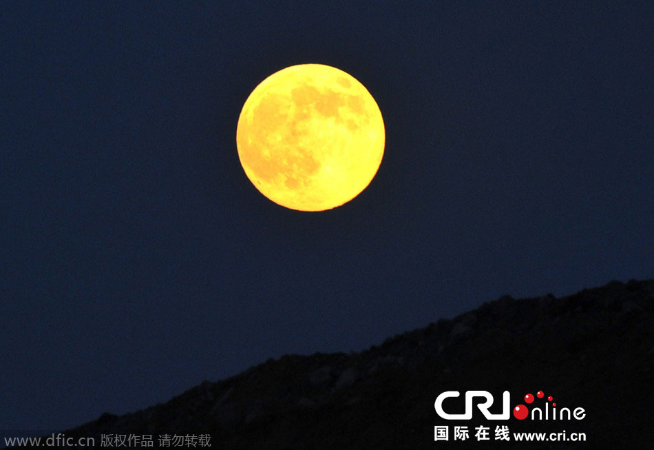 8月10日晚，一輪金燦燦的大月亮在遼寧省大連市東方升起。圖片來源：劉德斌/東方IC