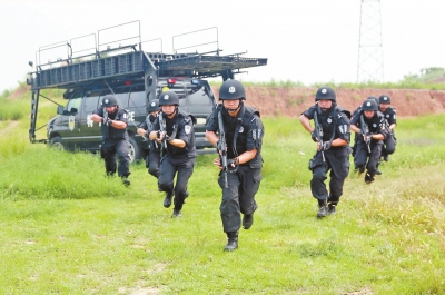 在拍攝現(xiàn)場，特警隊(duì)員下車后快速出擊。記者張琮攝影