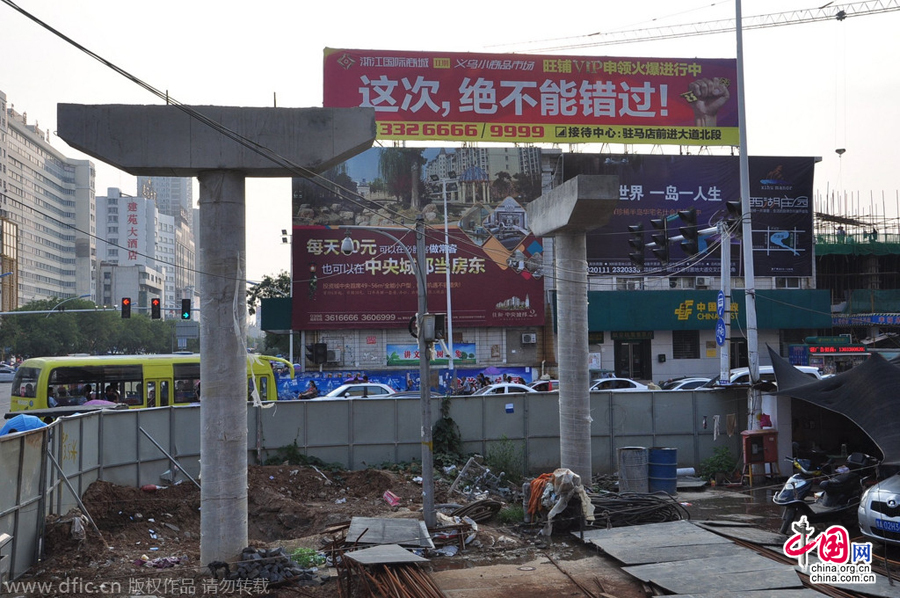 過(guò)街天橋一側(cè)的橋樁早已打好,可是對(duì)面的郵政銀行網(wǎng)點(diǎn)依舊在照常營(yíng)業(yè)。
