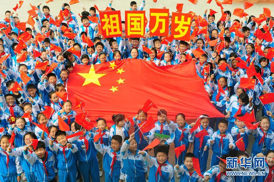9月26日，安徽省阜陽市北城小學(xué)分校的學(xué)生與國旗合影。