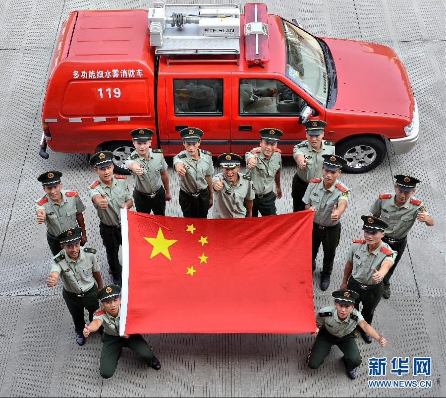  9月25日，武警浙江嘉興消防官兵與國旗合影。