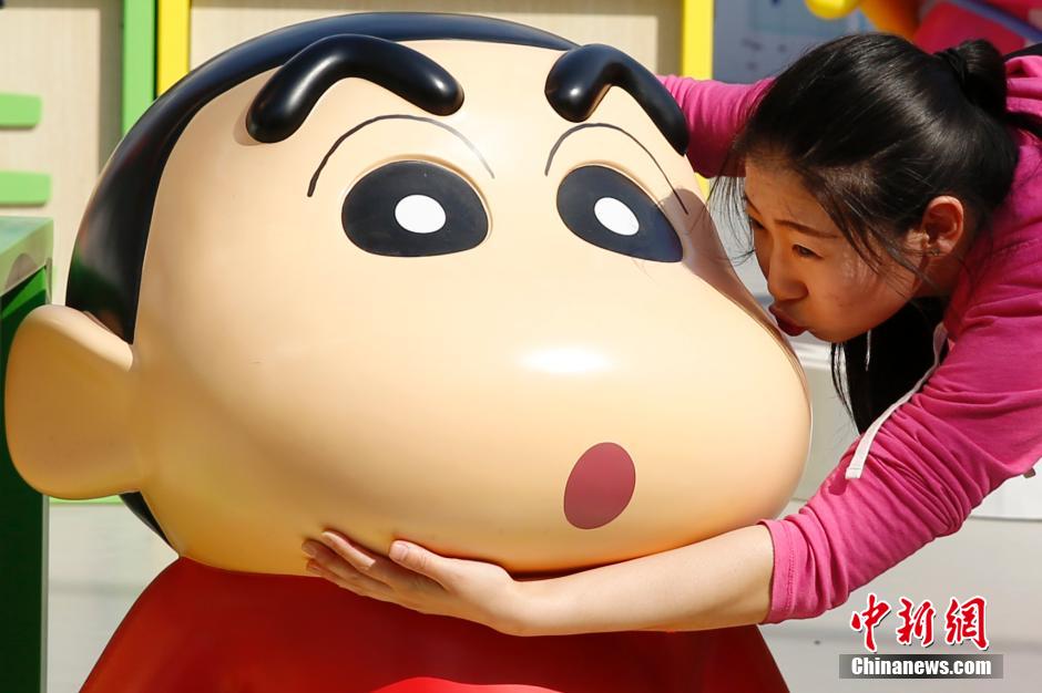 4月22日，游客與蠟筆小新合影?！跋灩P小新25周年紀(jì)念特展”日前在北京開展，吸引了不少市民游客。
