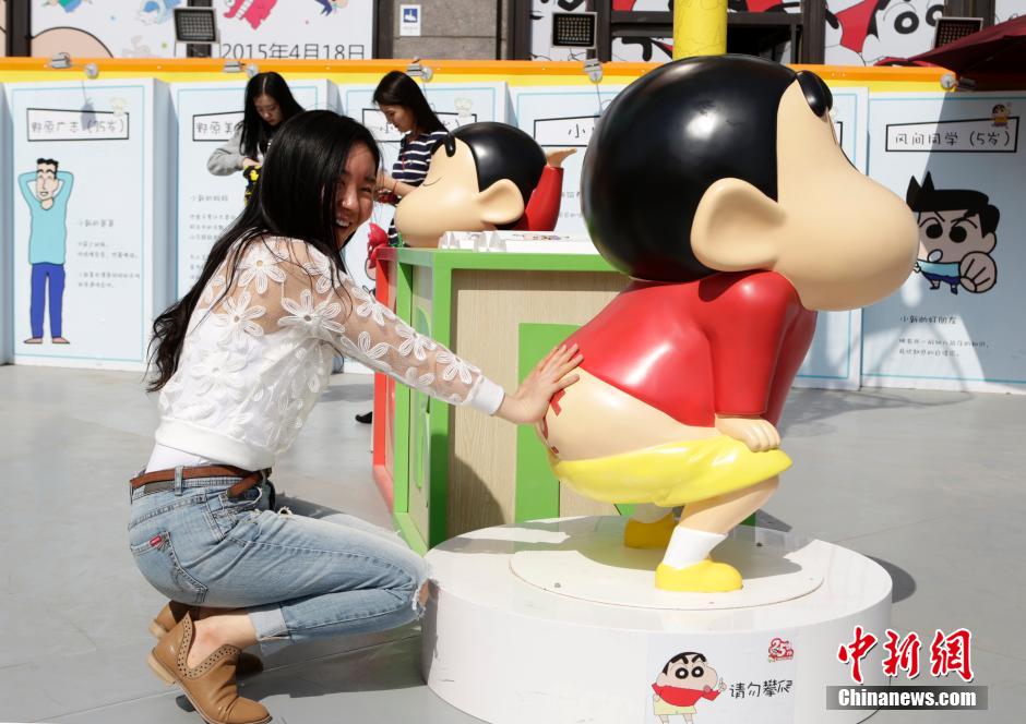 4月22日，游客與蠟筆小新合影。“蠟筆小新25周年紀(jì)念特展”日前在北京開展，吸引了不少市民游客。