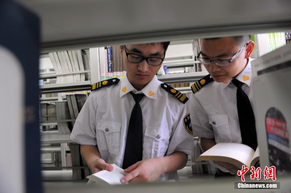 5月8日，武漢輕工大學(xué)圖書館保安吳濤與江力在圖書館交流學(xué)習(xí)。