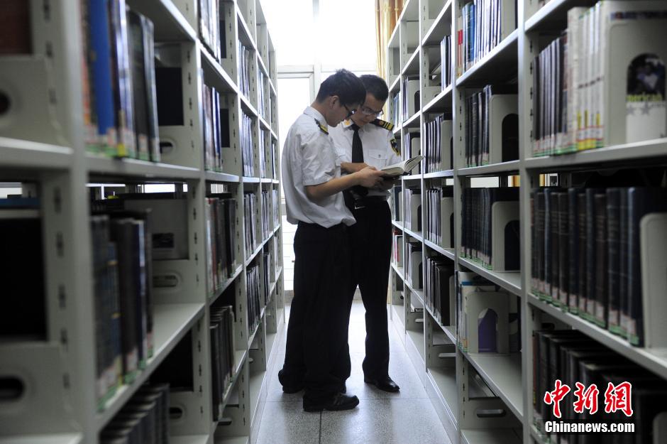 5月8日，武漢輕工大學(xué)保安吳濤與江力在圖書館交流學(xué)習(xí)。中新社發(fā) 張暢 攝