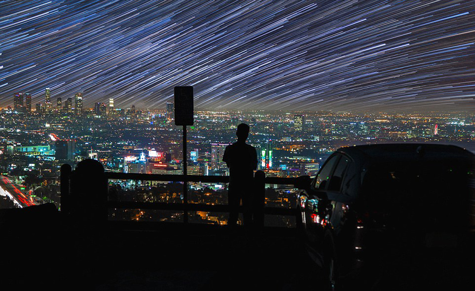 照片中，一名男子看著流星和隕星劃過天空。（網(wǎng)頁截圖）