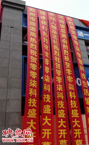 路邊一棟樓上懸掛著二三十條紅色條幅，全部是祝賀一家公司開業(yè)的。