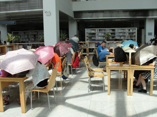 圖書館內(nèi)撐傘讀書的民眾。