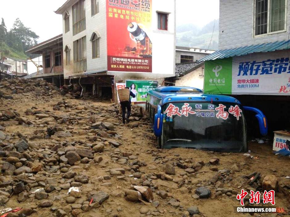 圖為山洪泥石流導(dǎo)沖進鄉(xiāng)鎮(zhèn)街道，導(dǎo)致客車被埋。