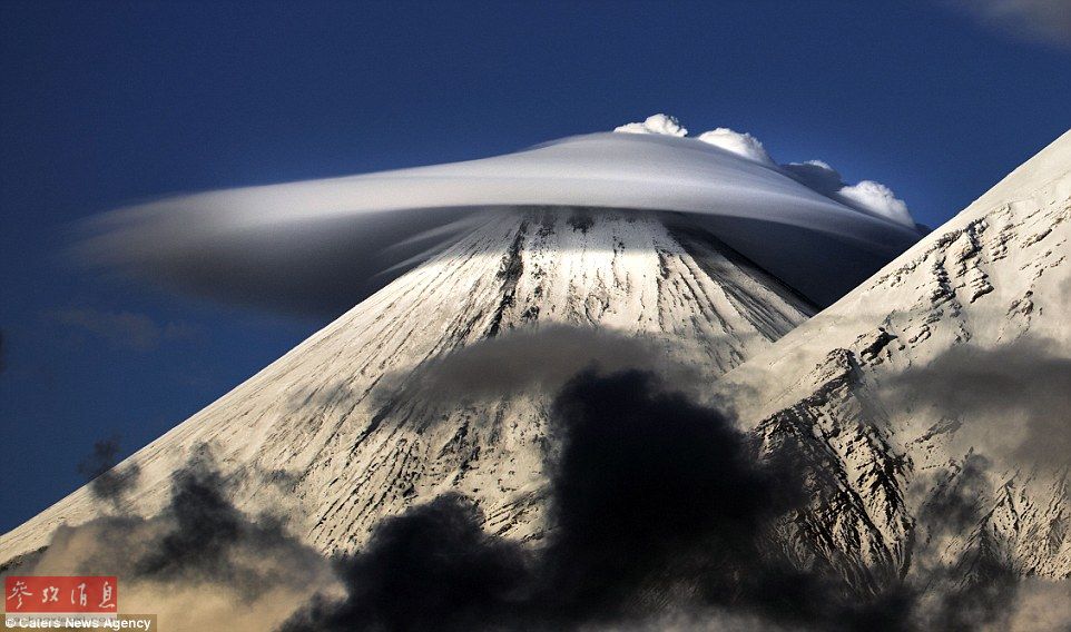 火山上籠罩著類似于外星飛碟形狀的云彩，場景猶如科幻大片。
