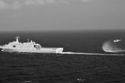 11日，抵達馬航飛機失聯(lián)海區(qū)的海軍井岡山艦與艦載直升機協(xié)同展開立體搜救行動。新華社發(fā)