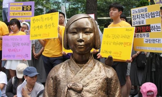 7月2日，在韓國首爾的日本駐韓國大使館前，民眾在慰安婦少女像旁手持標(biāo)語參加抗議活動。