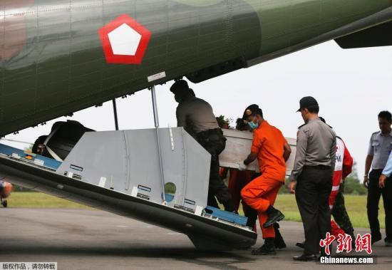 資料圖：當?shù)貢r間2015年1月19日，印尼龐卡蘭布翁，依斯干達空軍基地，救援隊成員正將裝有亞航失事飛機遇難者尸體的棺材抬上一架CN2950運輸機。