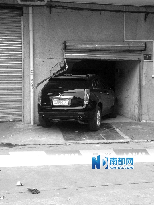 　昨日，凱迪拉克撞人后停在一倉(cāng)庫(kù)門口，車后有一攤血跡。 南都記者陳杰生攝