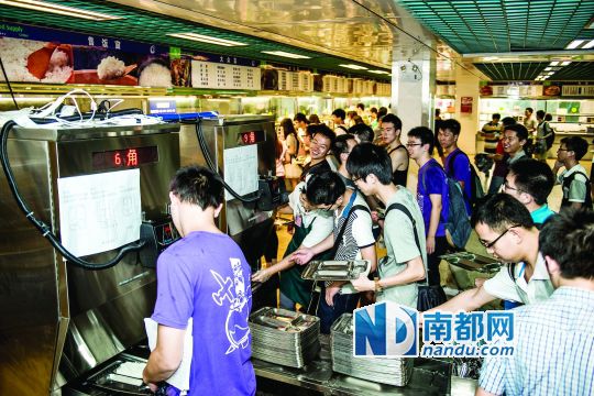昨日，華南理工大學(xué)一食堂內(nèi)，學(xué)生們正在使用新安裝的自動打飯機打飯。中新社發(fā)
