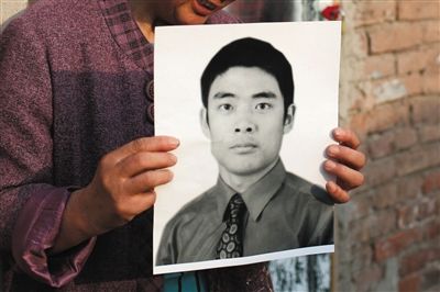 5月19日，朝陽北路，母親捧著張東文的遺像。新京報記者 侯少卿 攝