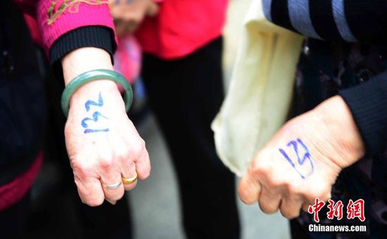 圖為10月28日，在江西九江市一家羊絨皮草服裝服飾博覽會(huì)現(xiàn)場(chǎng)，老人們正在頂著寒風(fēng)排隊(duì)等待領(lǐng)取10元代金劵。