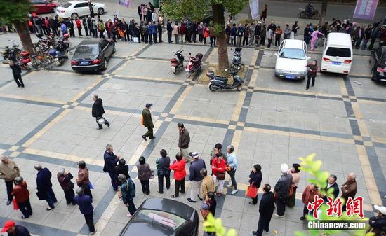 圖為10月28日，在江西九江市一家羊絨皮草服裝服飾博覽會(huì)現(xiàn)場(chǎng)，老人們正在頂著寒風(fēng)排隊(duì)等待領(lǐng)取10元代金劵。