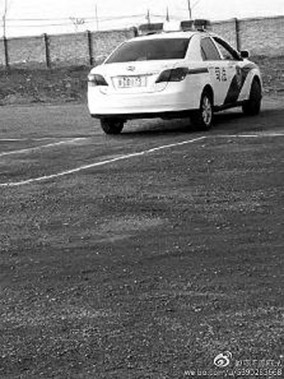 一輛車牌號 為“ 陜DD173”的制式警車停在一個劃著白線的場地上，車身標(biāo)有“司法”字樣