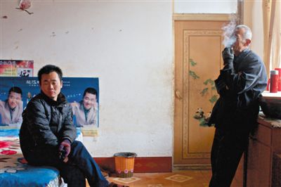 父親抽煙，兒子不語。逃跑的越南新娘，給袁迎賓父子帶來的是失落。新京報記者 周崗峰 攝
