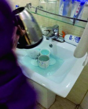 酒店服務員用潔廁液刷燒水壺和茶杯。