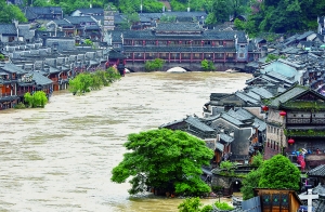 7月16日,沱江兩邊的商鋪和遠(yuǎn)處的虹橋仍淹沒在洪水中。 新華社發(fā)