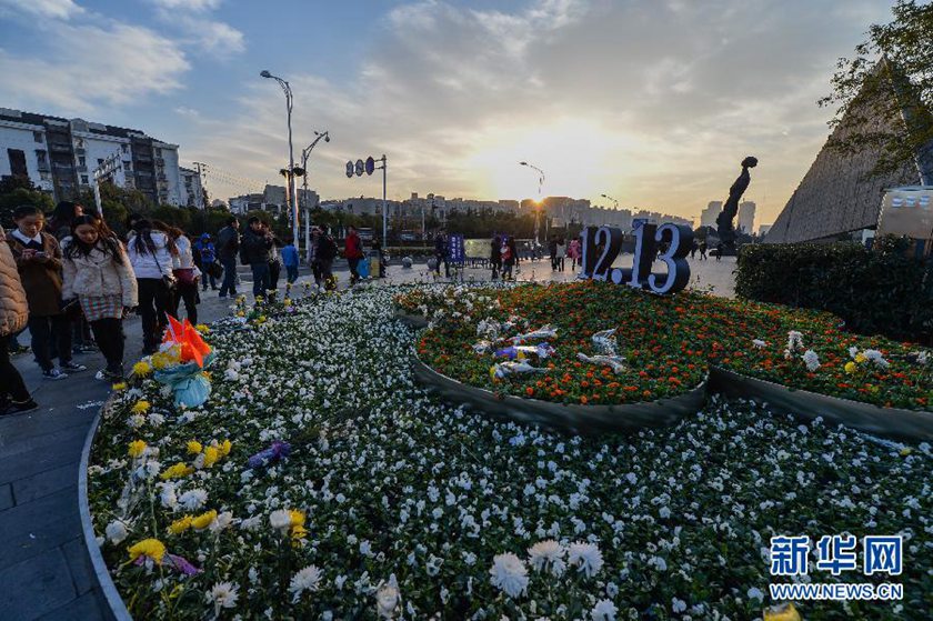 12月14日,觀眾在侵華日軍南京大屠殺遇難同胞紀(jì)念館前的“12·13”花壇上擺放鮮花祭奠遇難同胞。新華社記者 沈鵬 攝