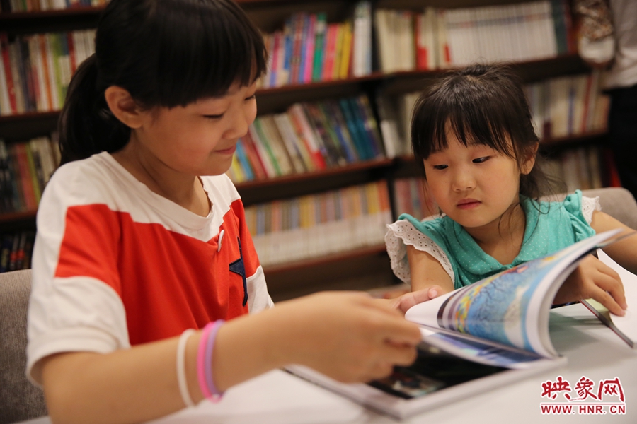 姐姐王藝茹，11歲，小學(xué)五年級學(xué)生；妹妹王有君，5歲：像喜歡看電視一樣喜歡看書。