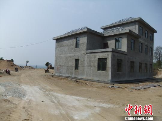 鴨河水庫庫區(qū)邊的新建別墅，一面墻上寫著“拆”，另一邊在加緊施工。吳揚(yáng)　攝