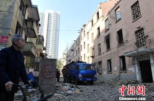一位花甲老人站在即將拆除的樓房旁，默默地與“蘇聯(lián)樓”告別。　翟羽佳　攝